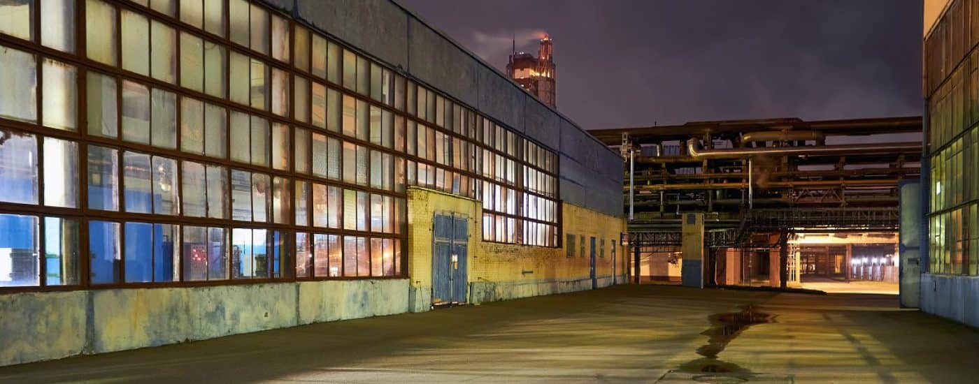 Night panorama of chemical plant building with dark blue sky. Compression buildings receding perspective, with copyspace.